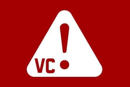 White triangle with an exclamation point and VC on a red background, indicating caution or alert.